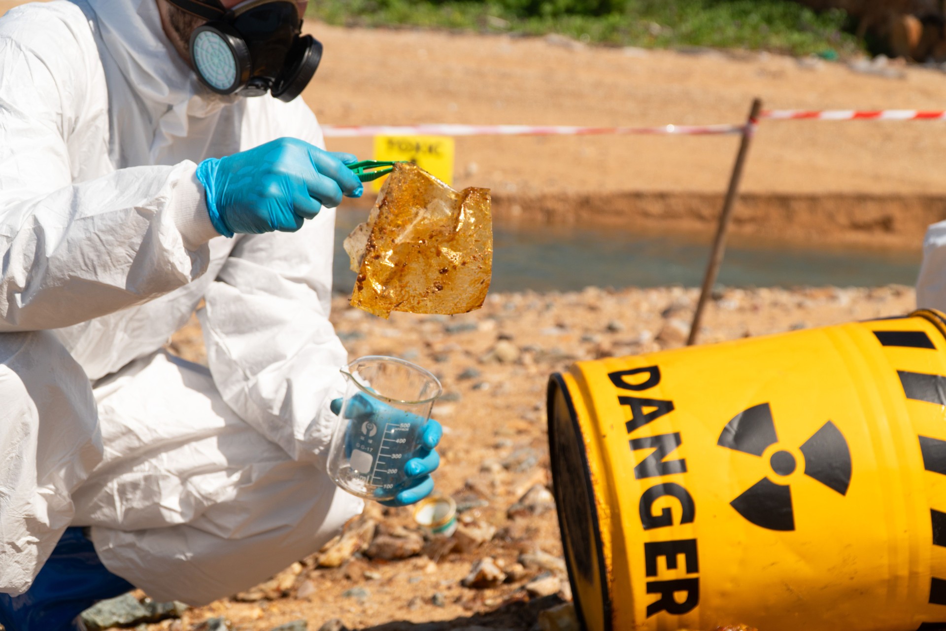 Team Ecologists in chemical PPE suits collect Toxic substance from oil league from refinery from sewers to nature to prevent chemical contamination and biohazard.